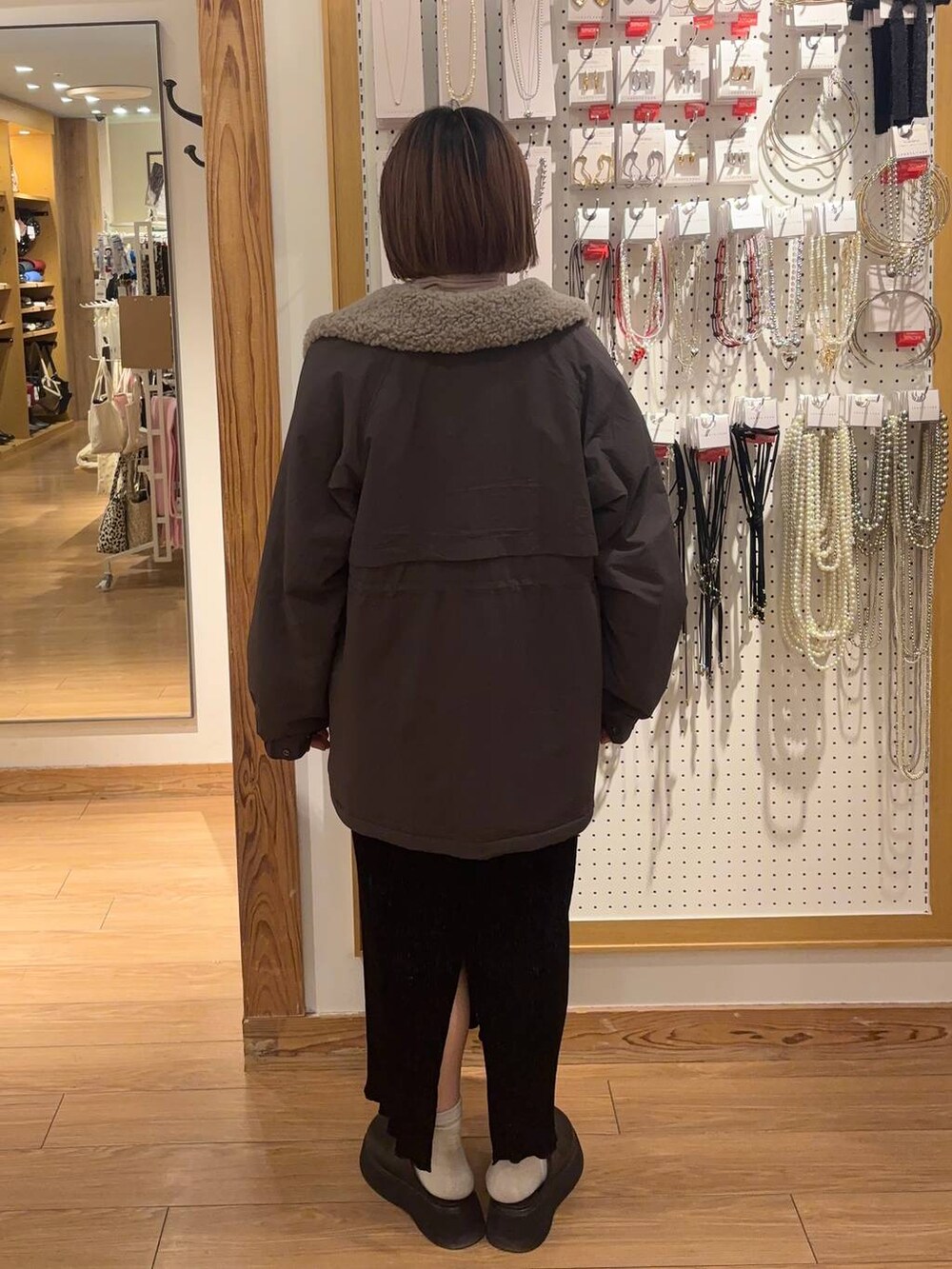 グレー系のその他アウター、ブラック系のサンダル、ブラック系のスカートを着用したレディースの冬コーディネートの3枚目の写真