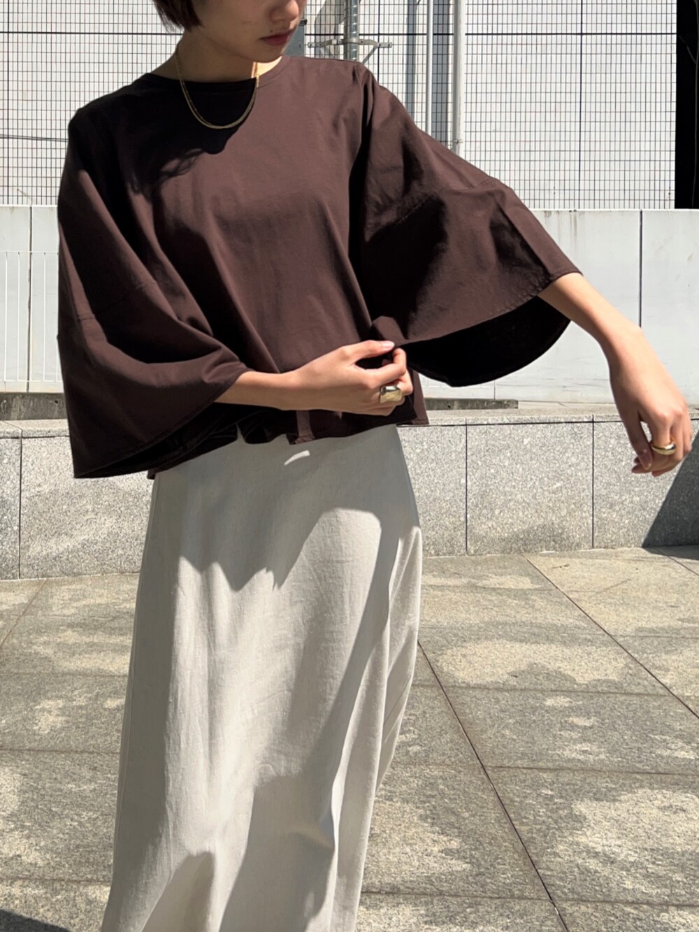 ホワイト系のスカート、ブラウン系のTシャツ/カットソーを着用したレディースの春コーディネートの8枚目の写真