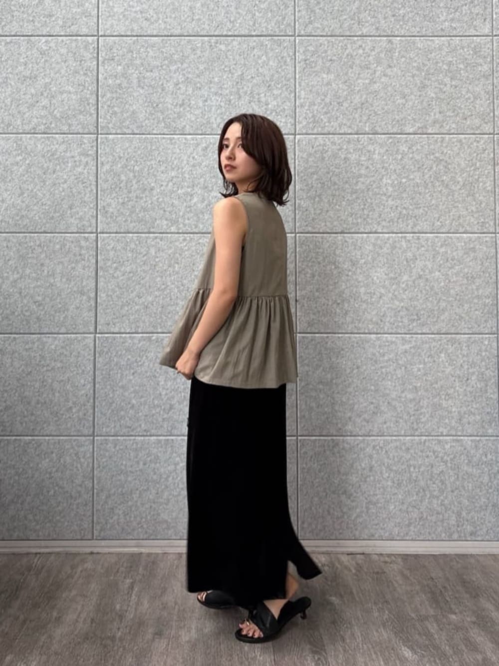 グリーン系のベストを着用したレディースの秋コーディネートの2枚目の写真