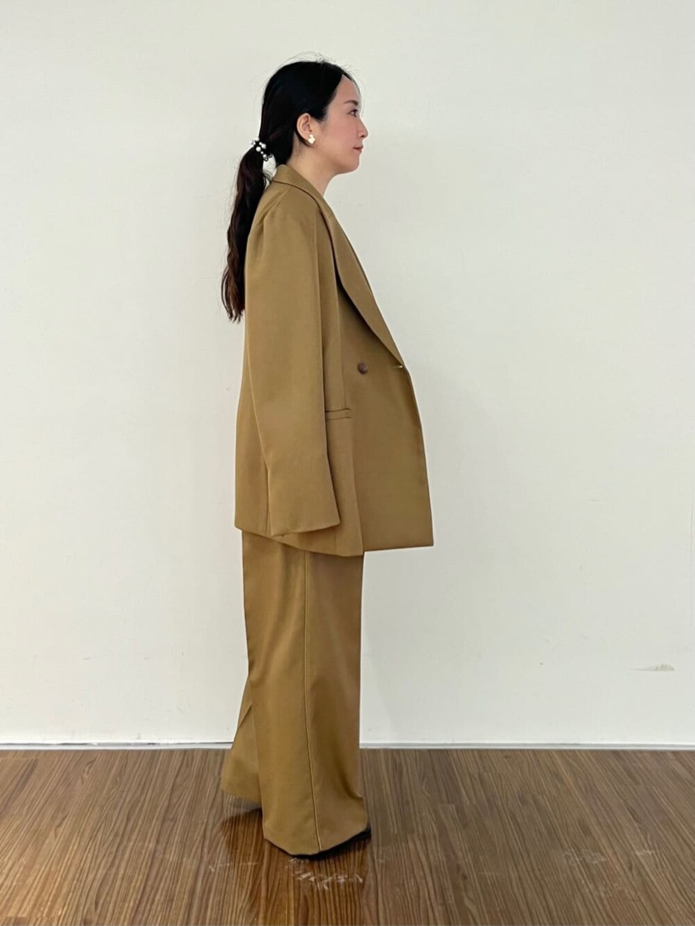 ブラック系のニット/セーター、イエロー系のその他パンツ、イエロー系のテーラードジャケットを着用したレディースの秋コーディネートの3枚目の写真