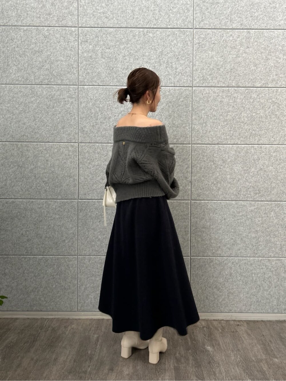 グレー系のニット/セーター、イエロー系のスカートを着用したレディースの秋コーディネートの4枚目の写真