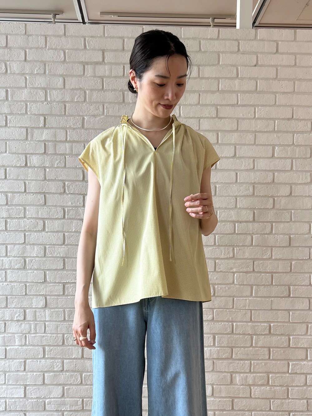 ブルー系のデニムパンツを着用したレディースの春コーディネートの7枚目の写真