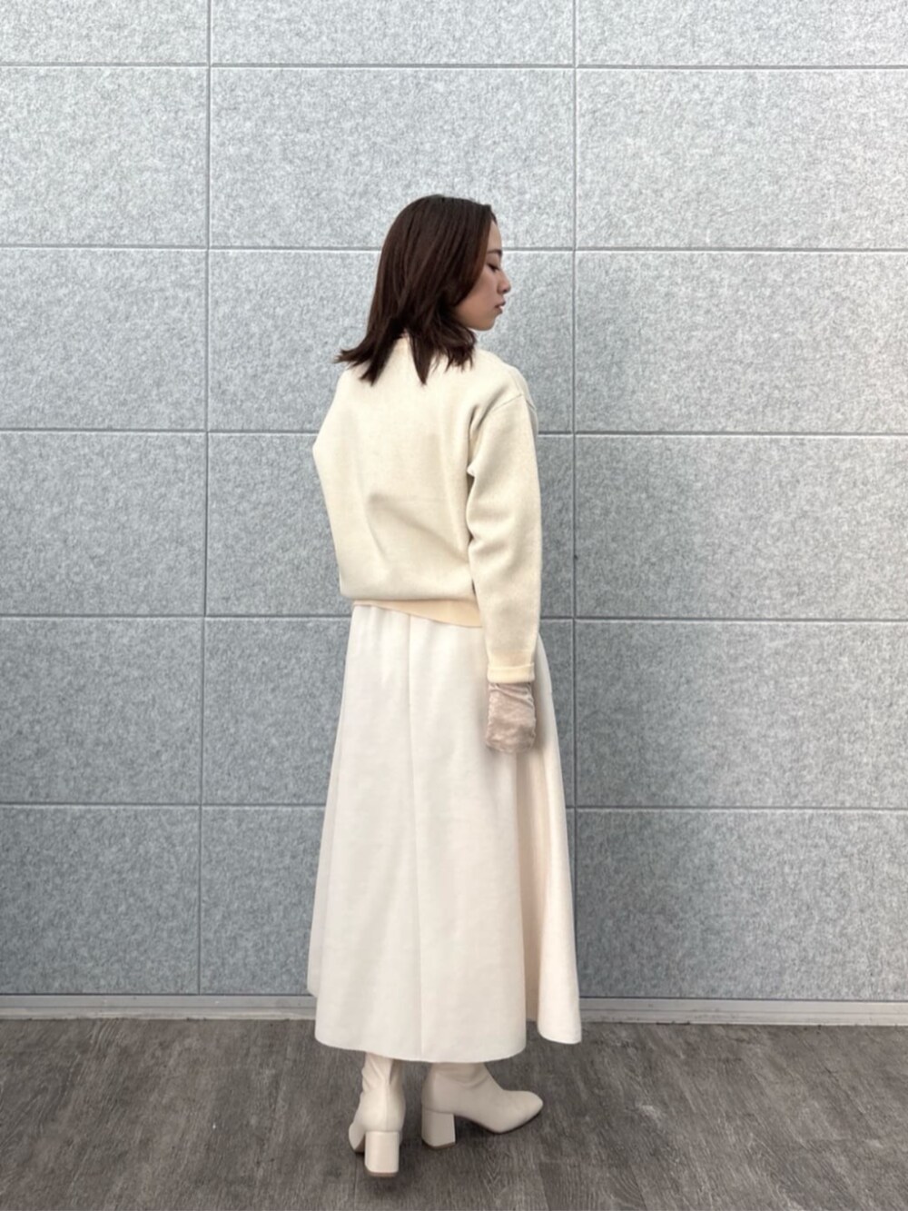 ホワイト系のスカート、ホワイト系のニット/セーター、ベージュ系のTシャツ/カットソーを着用したレディースの秋コーディネートの3枚目の写真