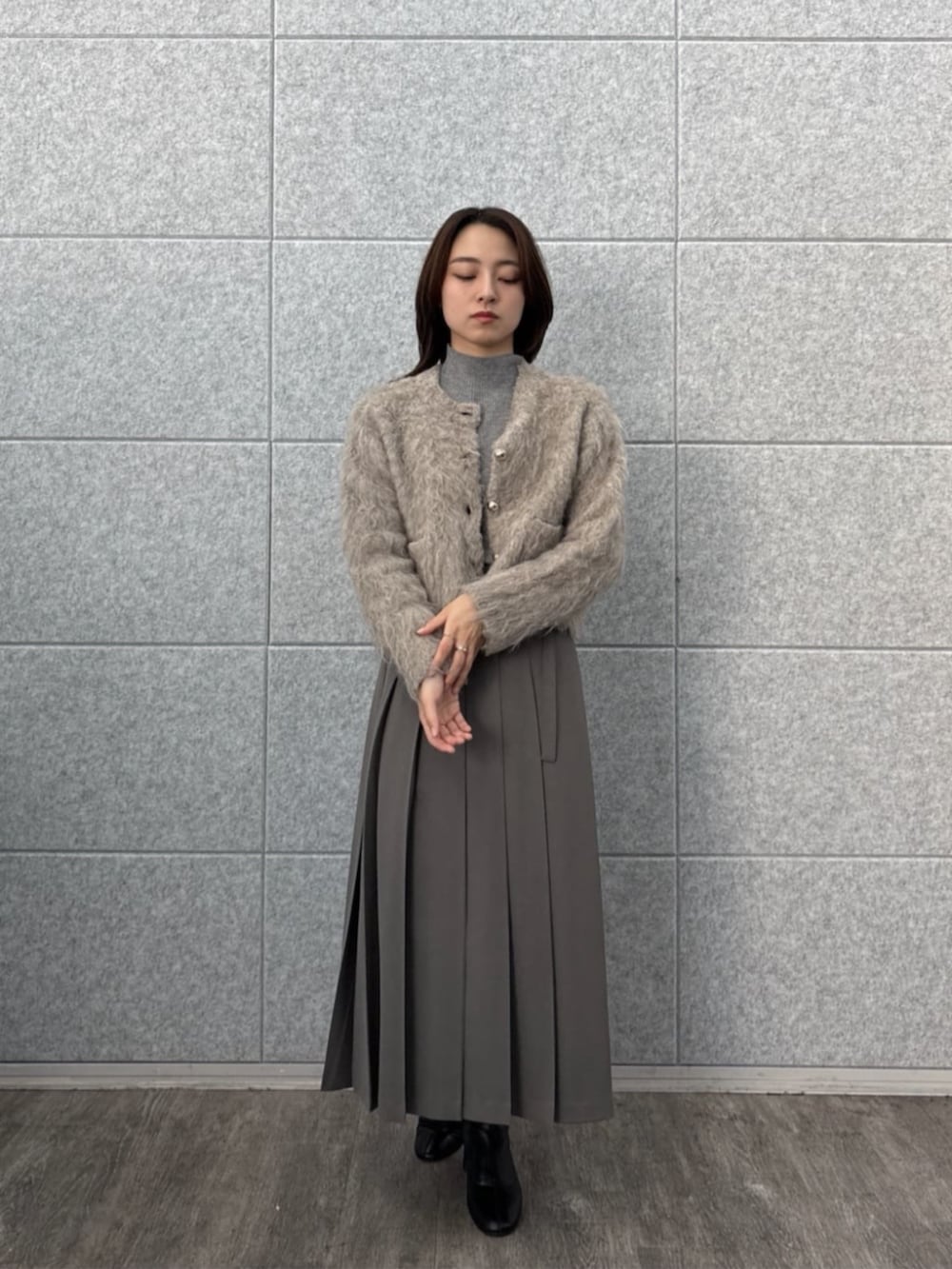 ブラウン系のニット/セーター、ベージュ系のカーディガン/ボレロ、グレー系のスカートを着用したレディースの秋コーディネートの3枚目の写真