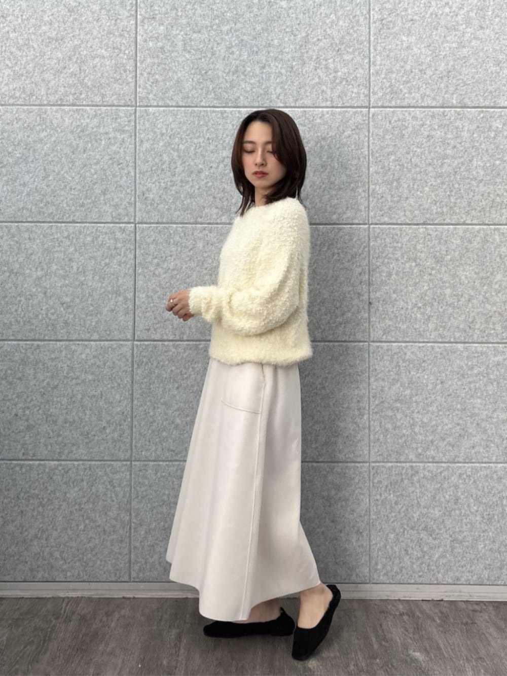 ホワイト系のニット/セーター、ホワイト系のスカートを着用したレディースの冬コーディネートの8枚目の写真