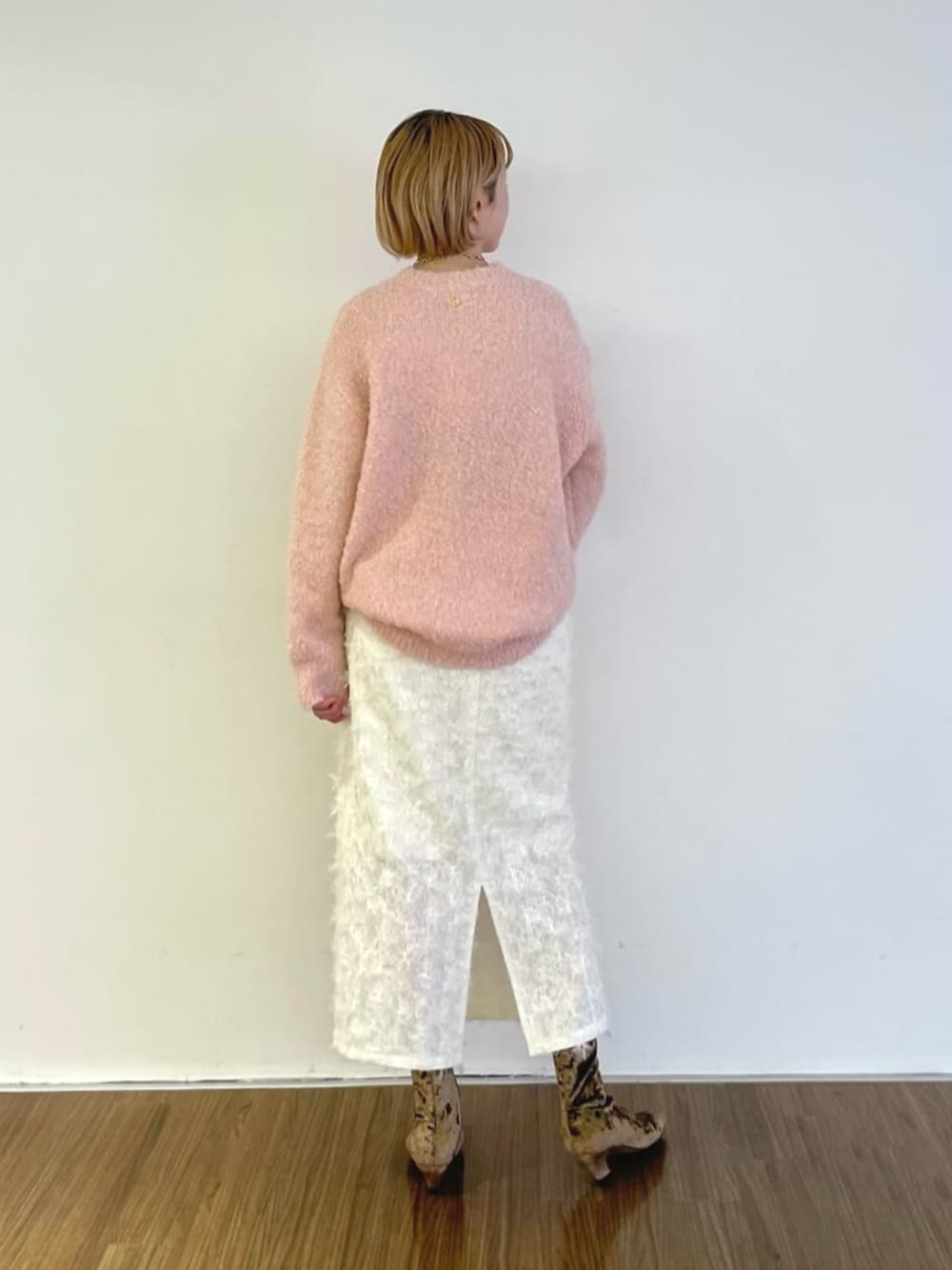 ホワイト系のスカート、ピンク系のニット/セーターを着用したレディースの冬コーディネートの4枚目の写真