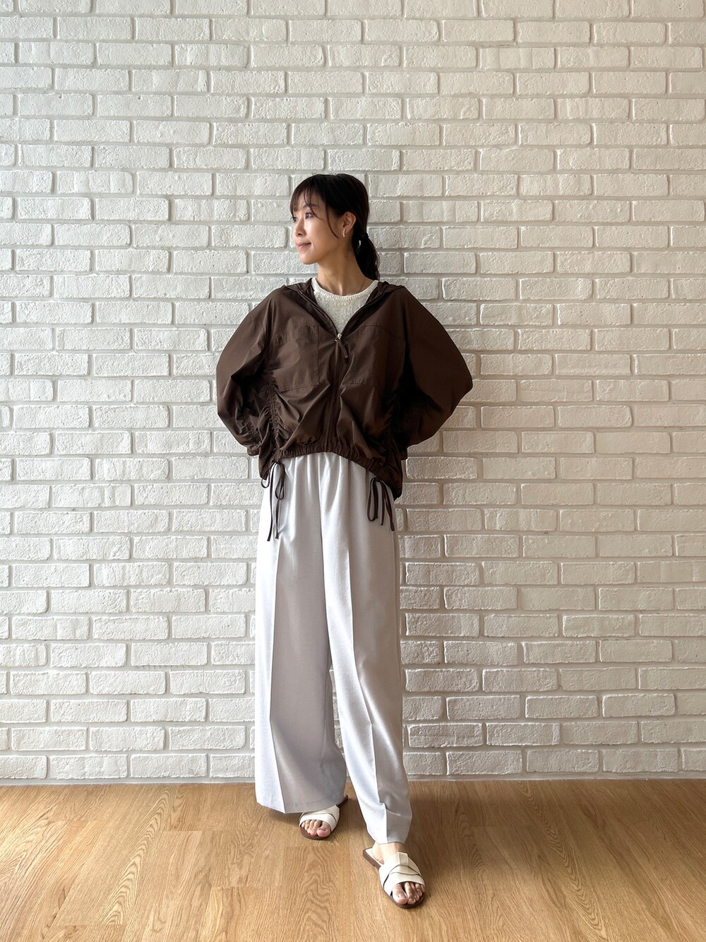ブラウン系のブルゾン、ベージュ系のタンクトップ、グレー系のその他パンツを着用したレディースの夏コーディネートの3枚目の写真