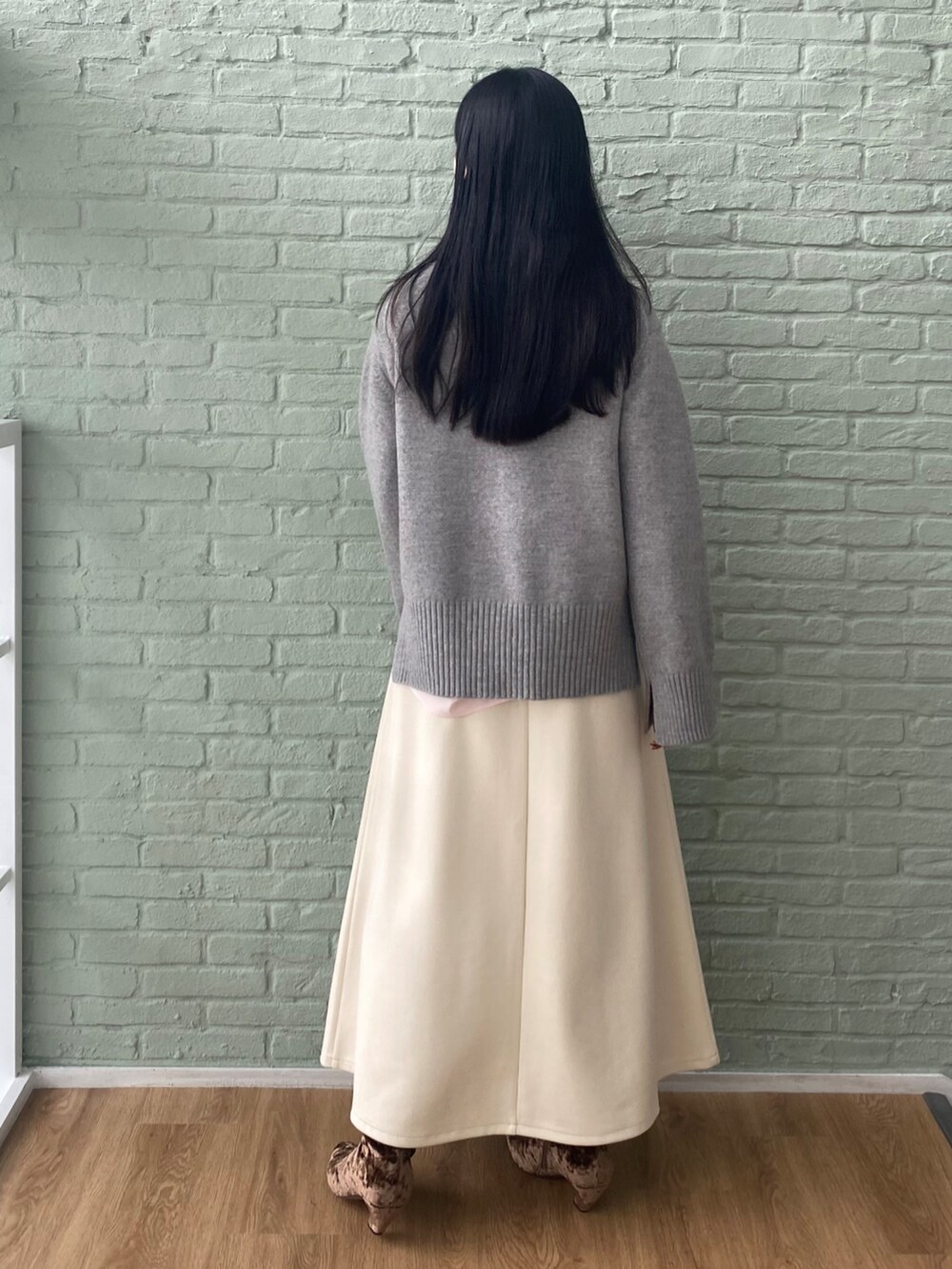 ホワイト系のスカート、グレー系のニット/セーター、ピンク系のシャツ/ブラウスを着用したレディースの秋コーディネートの4枚目の写真