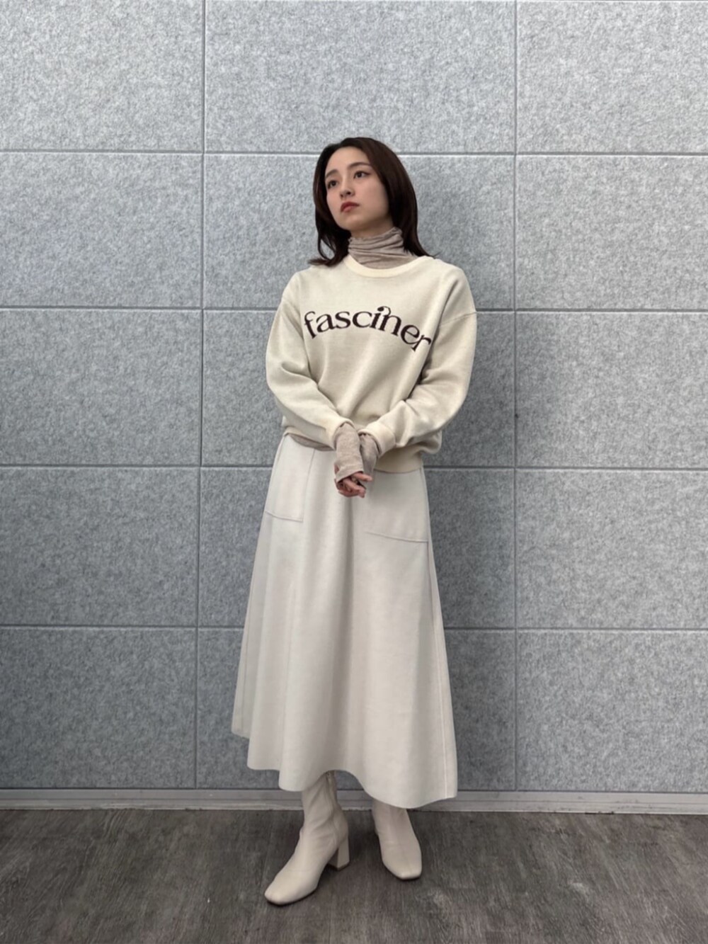ホワイト系のスカート、ホワイト系のニット/セーター、ベージュ系のTシャツ/カットソーを着用したレディースの秋コーディネートの6枚目の写真