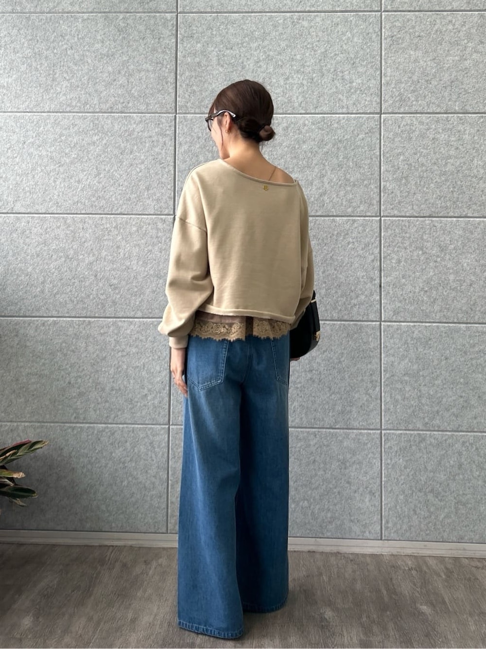 ベージュ系のスウェット、ブルー系のデニムパンツを着用したレディースの冬コーディネートの3枚目の写真