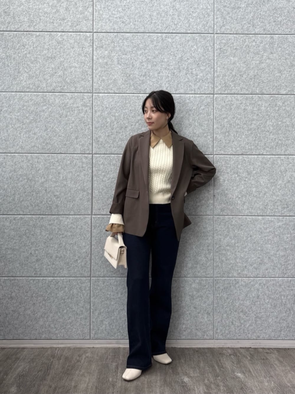 ブラウン系のテーラードジャケット、ブルー系のデニムパンツ、ホワイト系のニット/セーターを着用したレディースの秋コーディネートの2枚目の写真