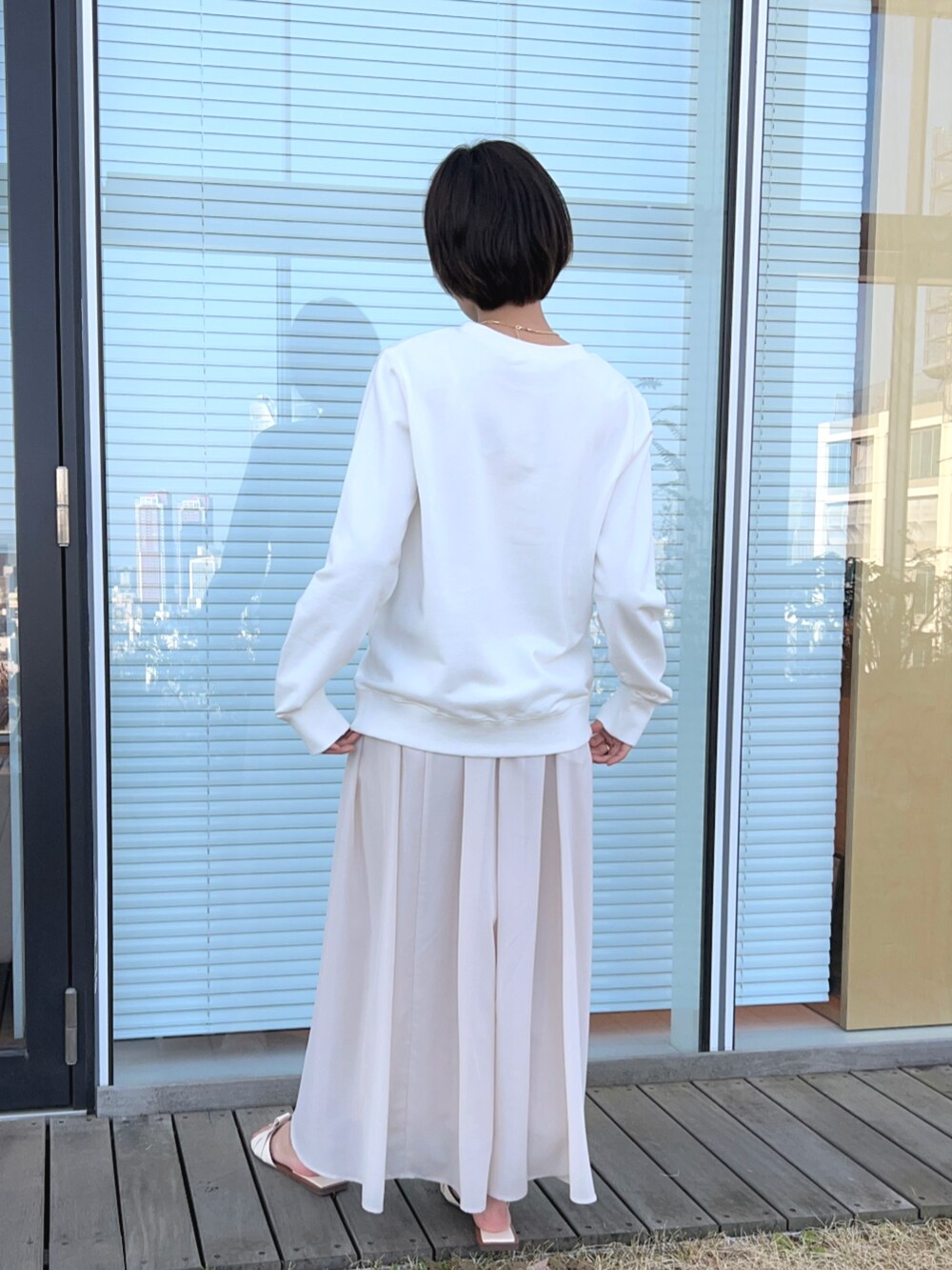ベージュ系のスカート、ホワイト系のスウェットを着用したレディースの春コーディネートの3枚目の写真