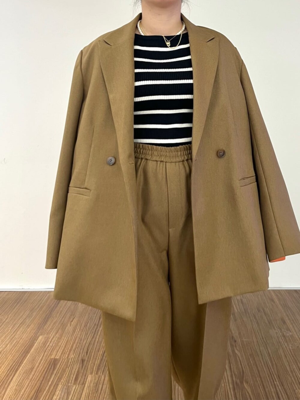 ブラック系のニット/セーター、イエロー系のその他パンツ、イエロー系のテーラードジャケットを着用したレディースの秋コーディネートの5枚目の写真