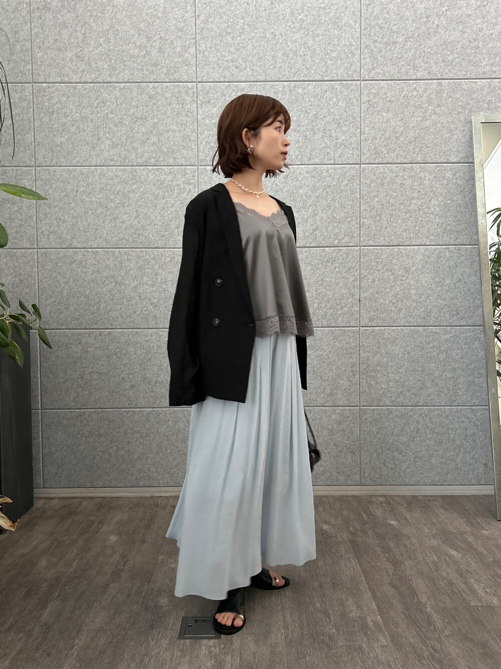 グレー系のタンクトップ、ブラック系のテーラードジャケット、ブルー系のその他パンツを着用したレディースの夏コーディネートの3枚目の写真