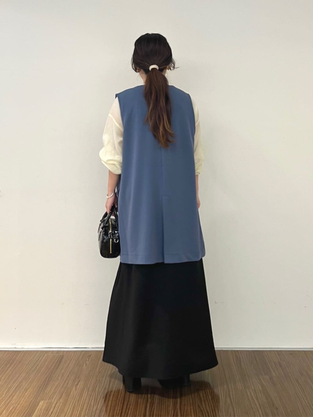 ブラック系のワンピース、ブルー系のベスト、ホワイト系のシャツ/ブラウスを着用したレディースの秋コーディネートの5枚目の写真