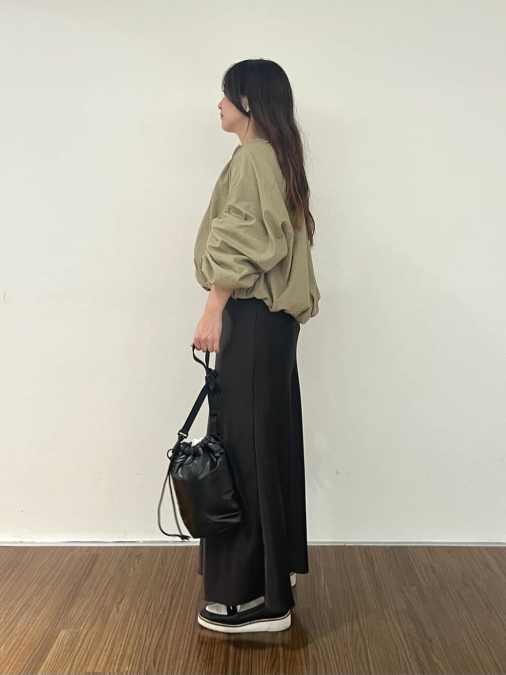 ブラウン系のブルゾン、グレー系のスカート、ベージュ系のニット/セーターを着用したレディースの秋コーディネートの3枚目の写真