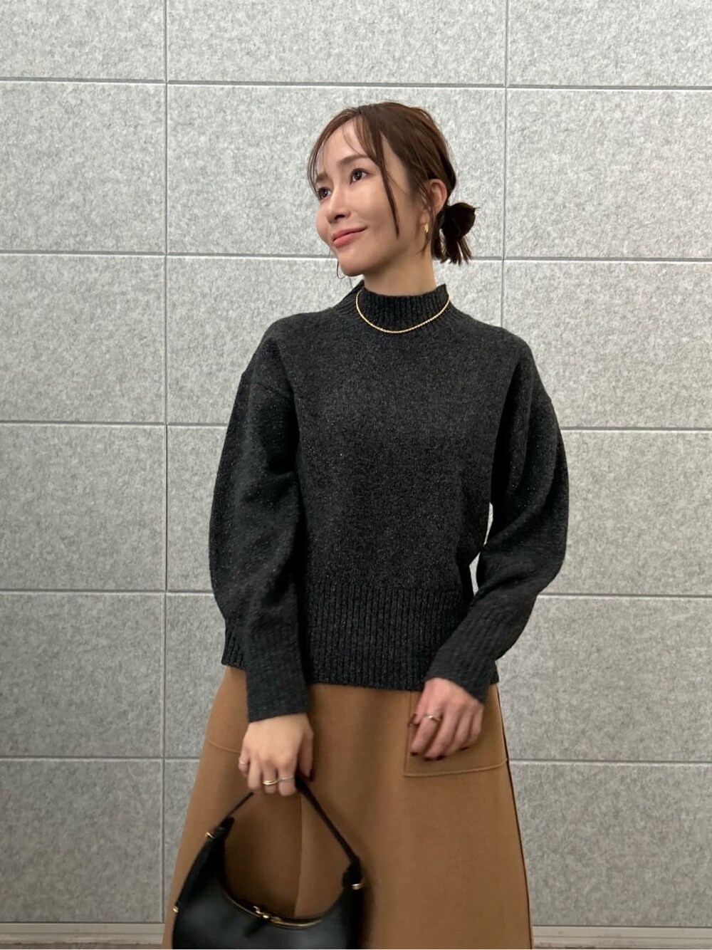 グレー系のニット/セーター、イエロー系のスカートを着用したレディースの秋コーディネートの7枚目の写真