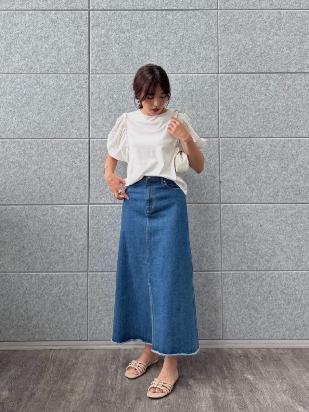 ブルー系のデニムスカート、ホワイト系のTシャツ/カットソーを着用したレディースの夏コーディネートの4枚目の写真