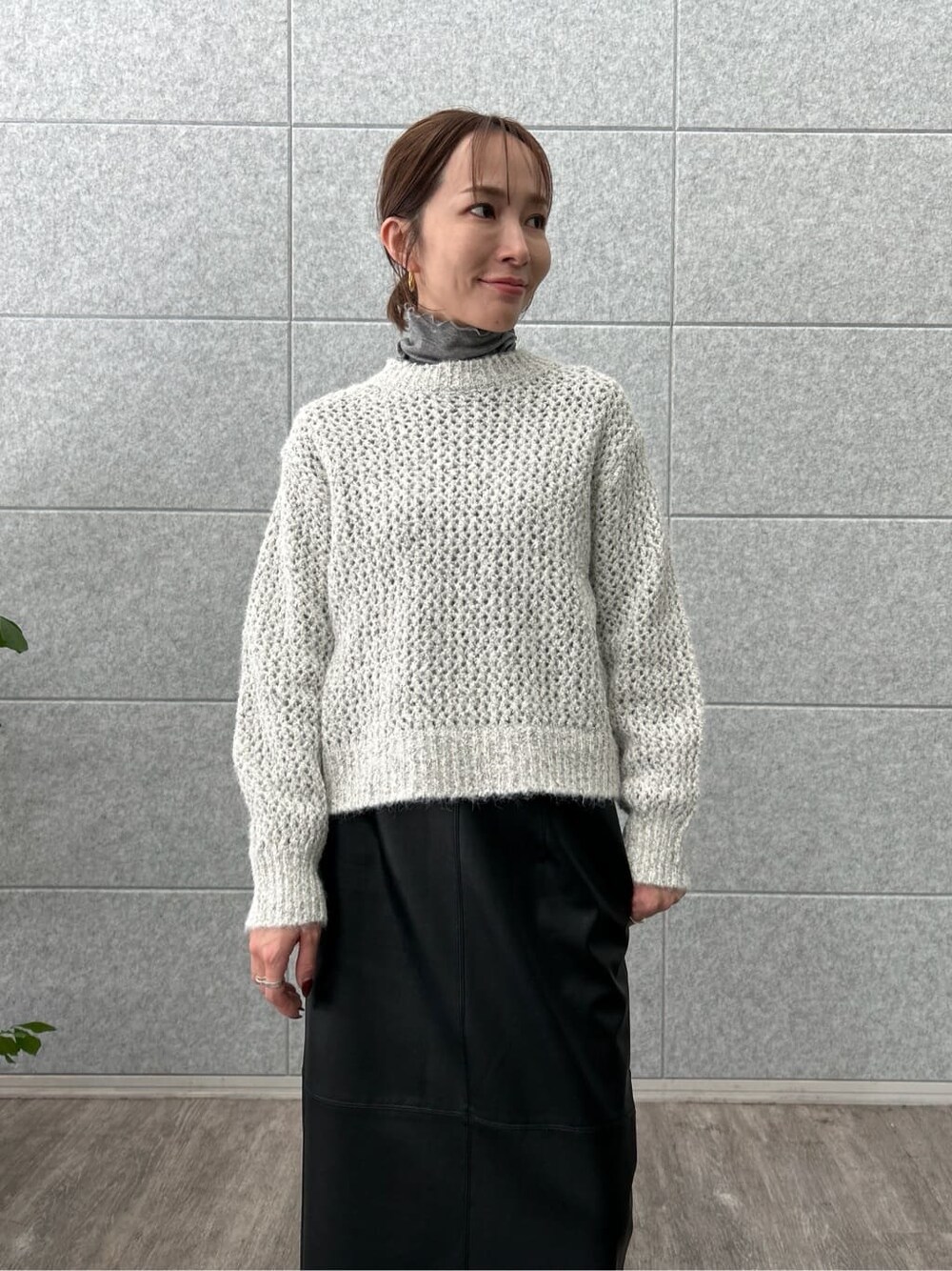 グレー系のニット/セーター、グレー系のTシャツ/カットソー、ブラック系のスカートを着用したレディースの冬コーディネートの7枚目の写真