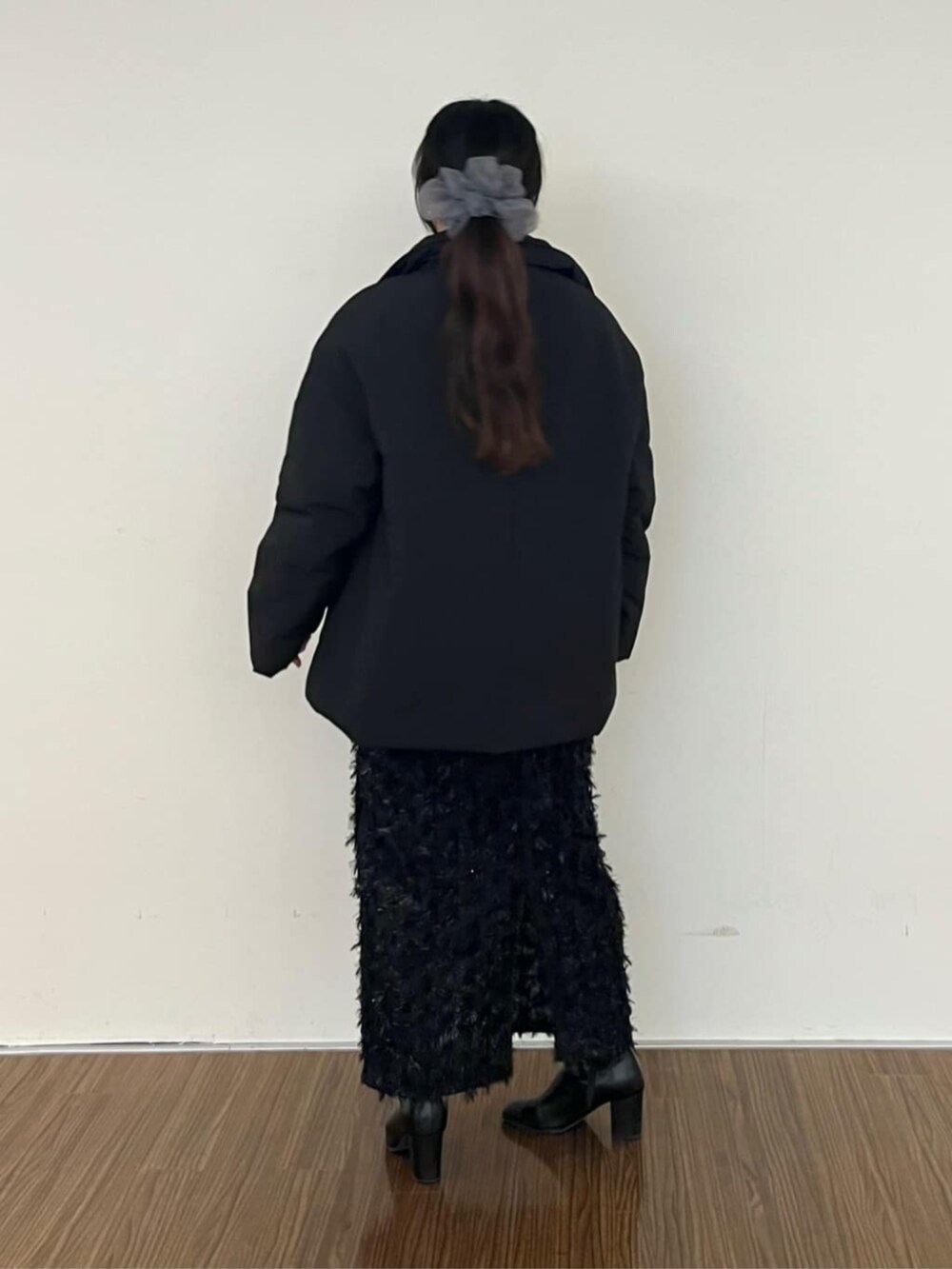 ブラック系のスカート、ブラック系のその他アウター、グレー系のニット/セーターを着用したレディースの冬コーディネートの3枚目の写真