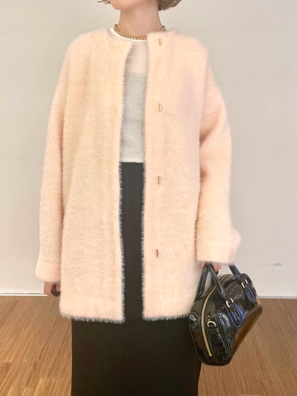 ピンク系のカーディガン/ボレロ、ブラック系のスカート、ホワイト系のTシャツ/カットソーを着用したレディースの秋コーディネートの6枚目の写真