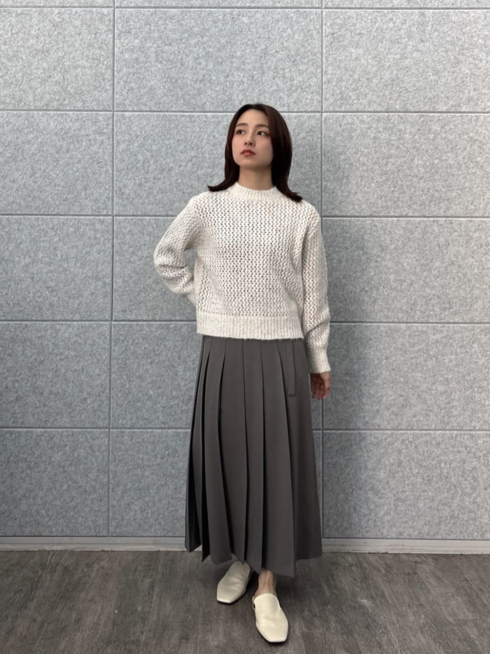 グレー系のスカート、ホワイト系のニット/セーターを着用したレディースの秋コーディネートの5枚目の写真