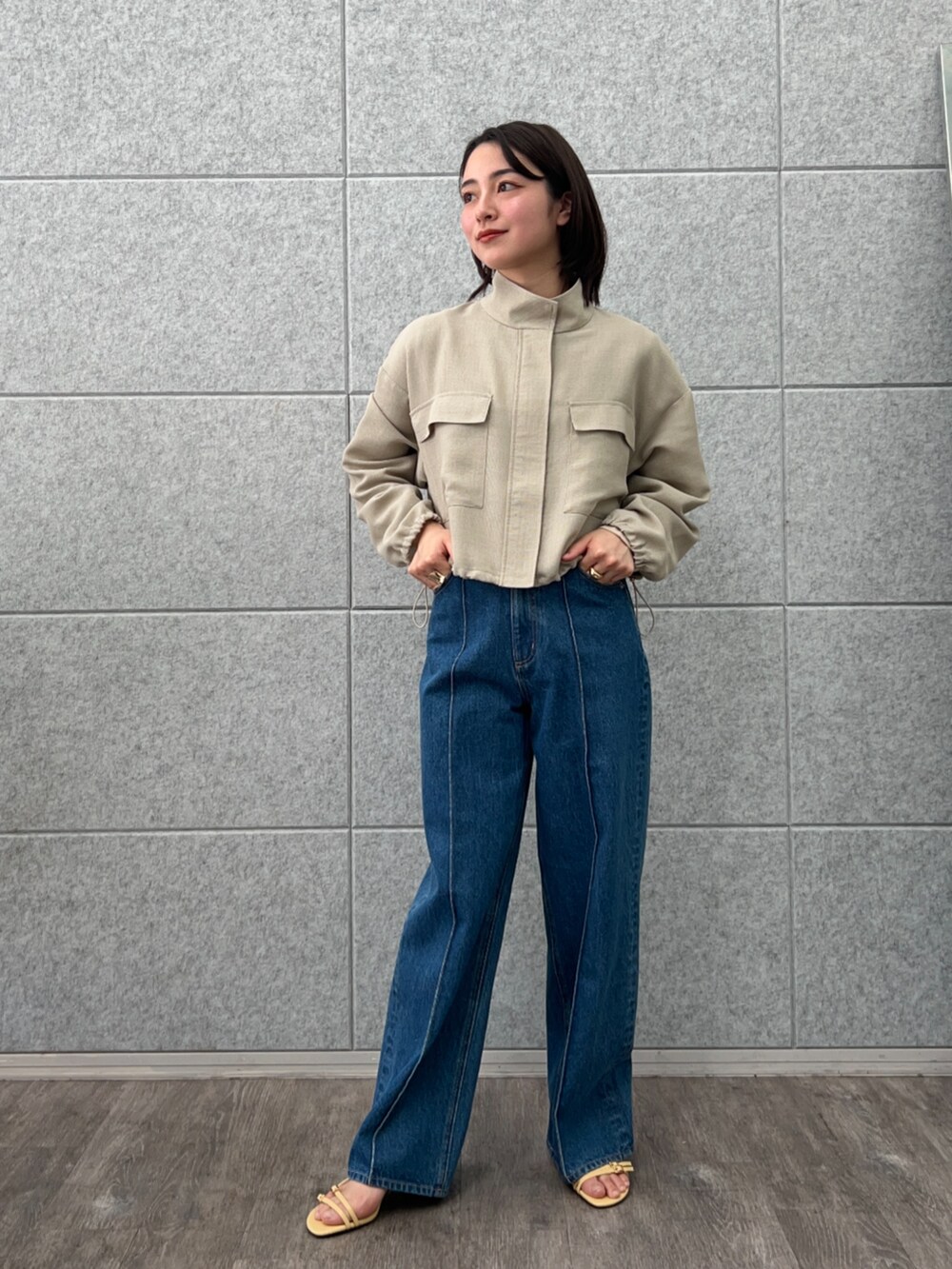 ブルー系のデニムパンツ、グリーン系のブルゾンを着用したレディースの春コーディネートの2枚目の写真