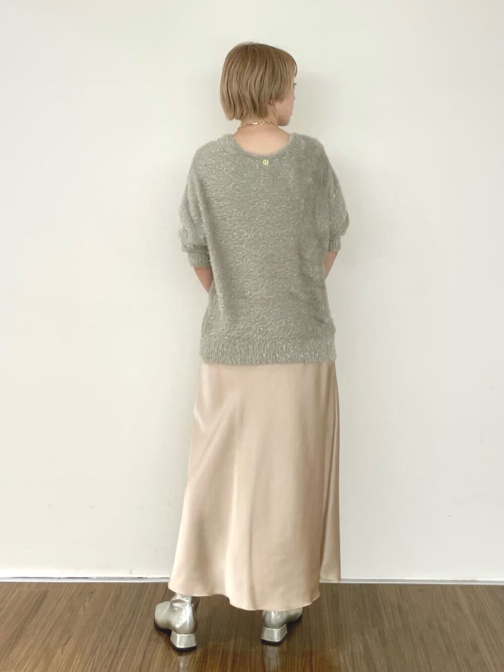 ベージュ系のスカート、グリーン系のニット/セーターを着用したレディースの冬コーディネートの5枚目の写真