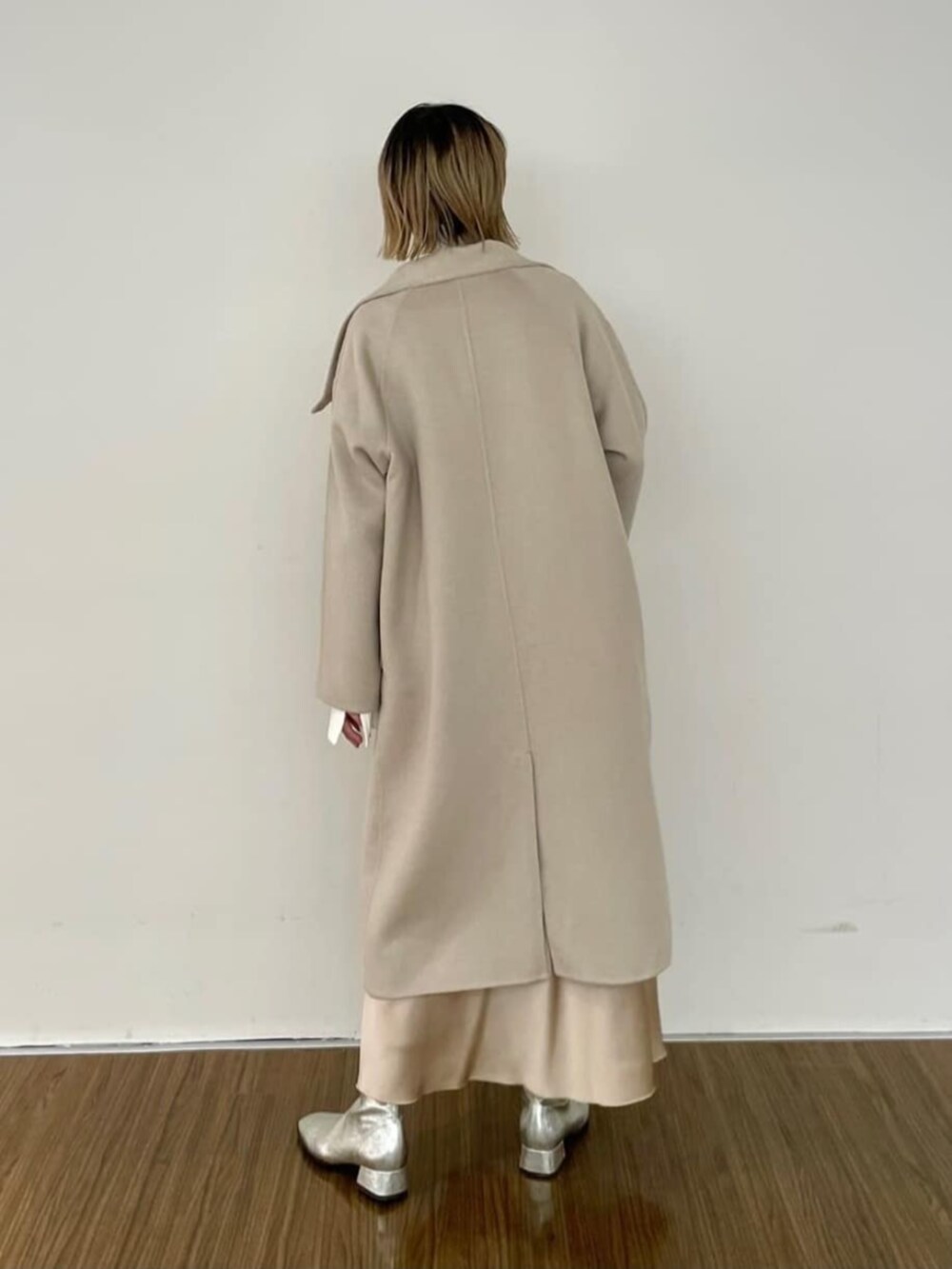 ベージュ系のスカート、ホワイト系のニット/セーター、ベージュ系のその他アウターを着用したレディースの秋コーディネートの5枚目の写真