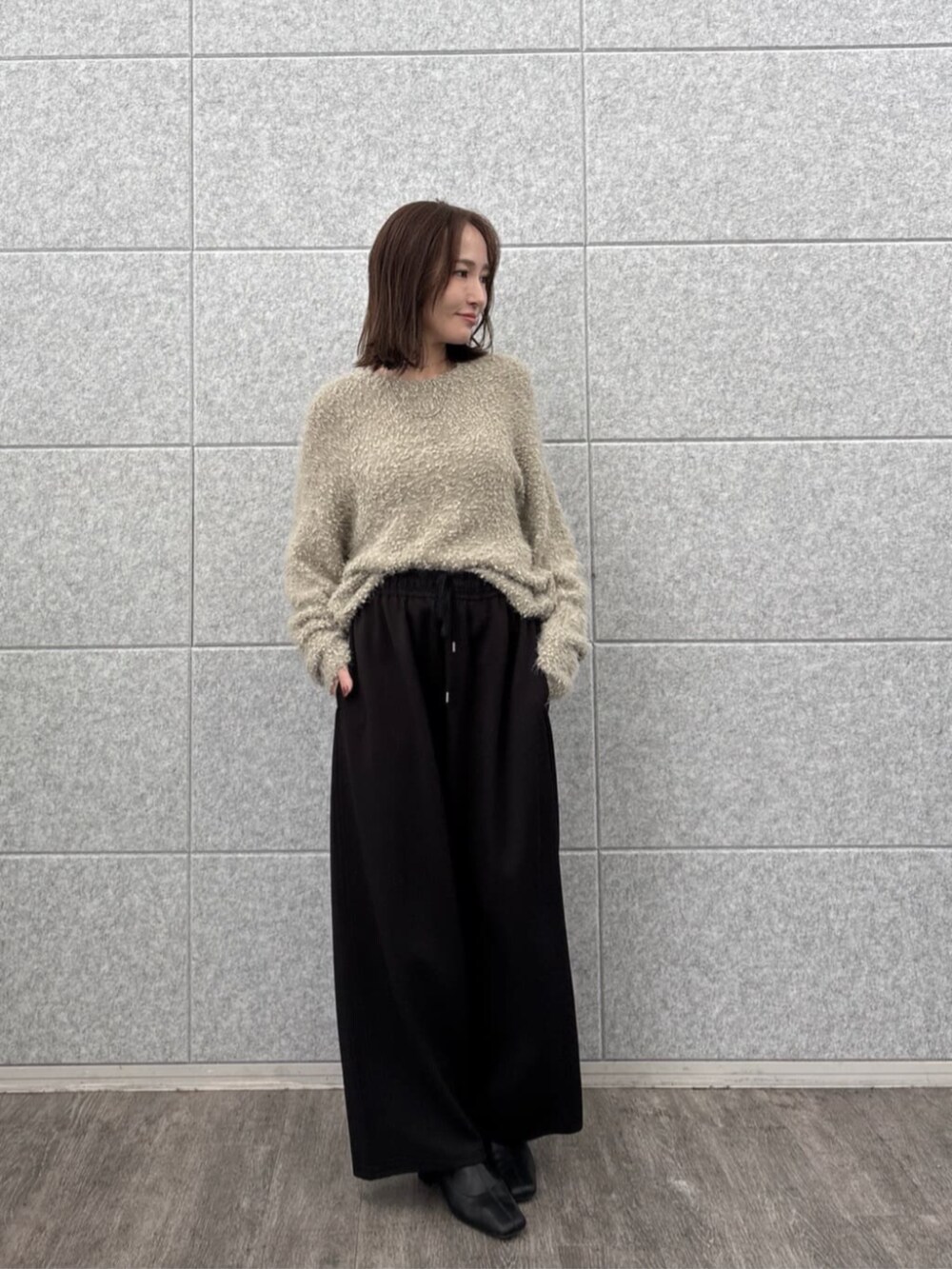 ブラック系のその他パンツ、ベージュ系のニット/セーターを着用したレディースの秋コーディネートの2枚目の写真
