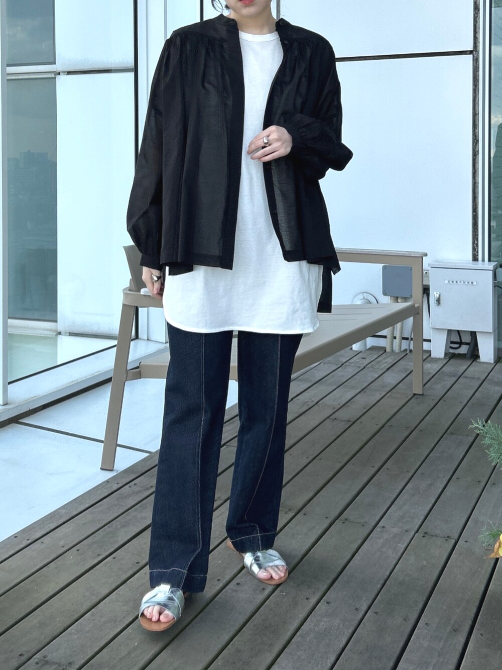 ブルー系のデニムパンツ、ホワイト系のTシャツ/カットソー、ブラック系のシャツ/ブラウスを着用したレディースの春コーディネートの3枚目の写真