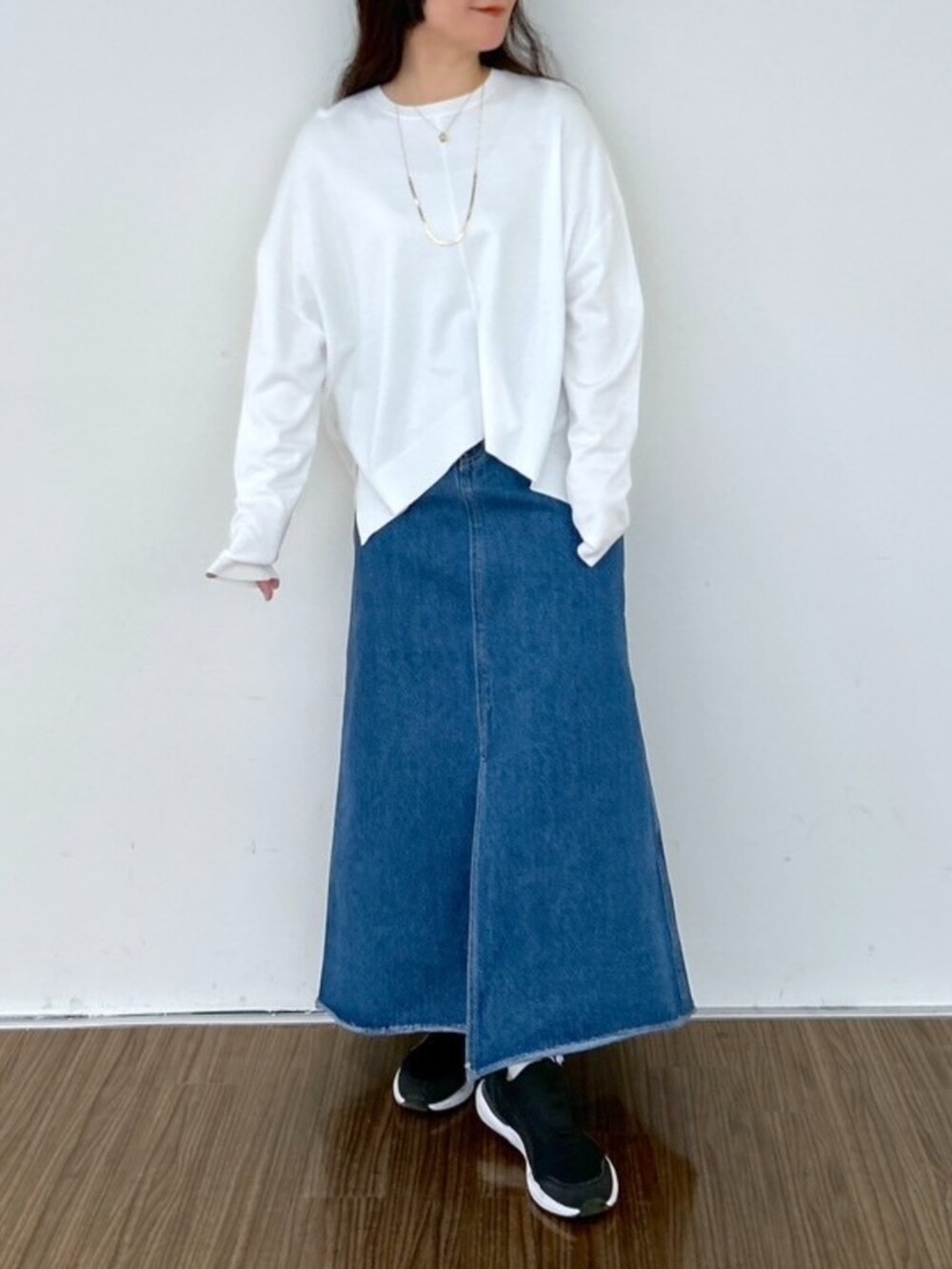 ブルー系のデニムスカート、ホワイト系のニット/セーターを着用したレディースの春コーディネートの2枚目の写真