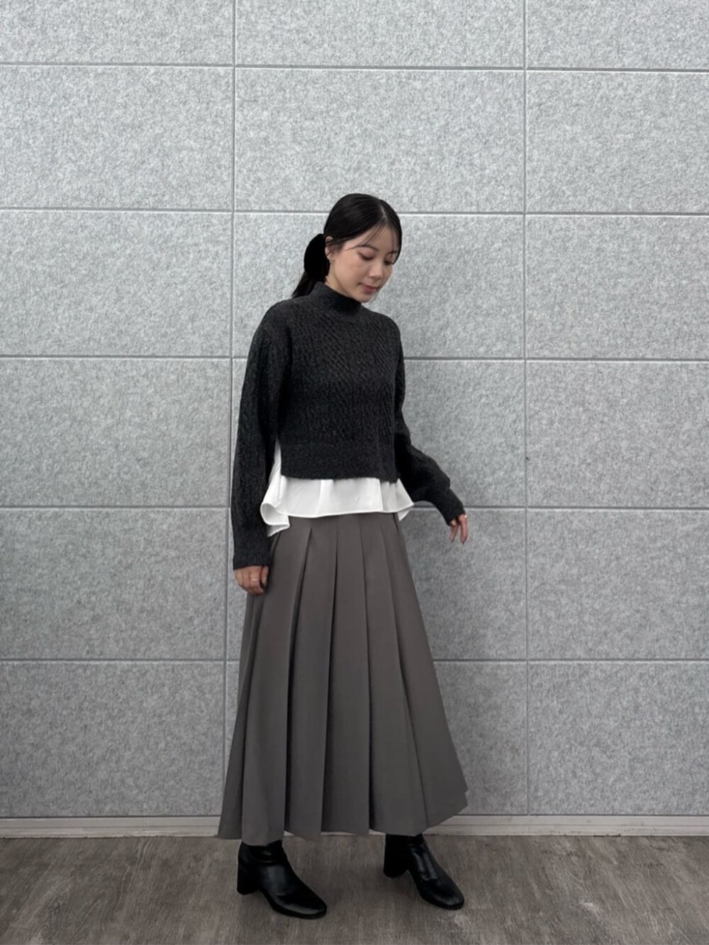 グレー系のスカート、グレー系のニット/セーターを着用したレディースの秋コーディネートの7枚目の写真