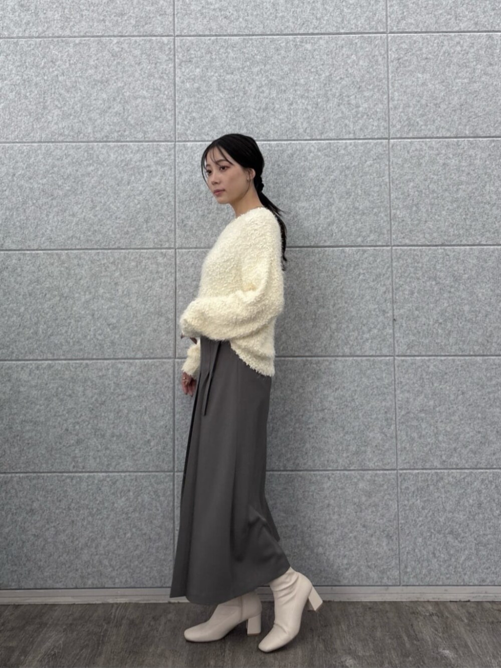 ホワイト系のニット/セーター、グレー系のスカートを着用したレディースの秋コーディネートの3枚目の写真