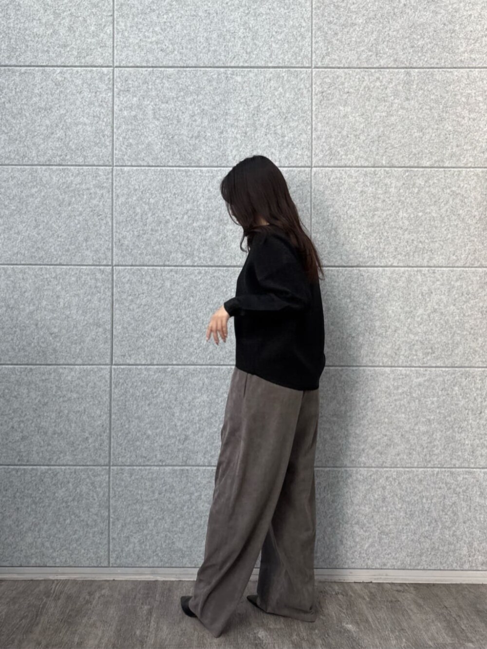グレー系のその他パンツ、ブラック系のニット/セーターを着用したレディースの秋コーディネートの2枚目の写真