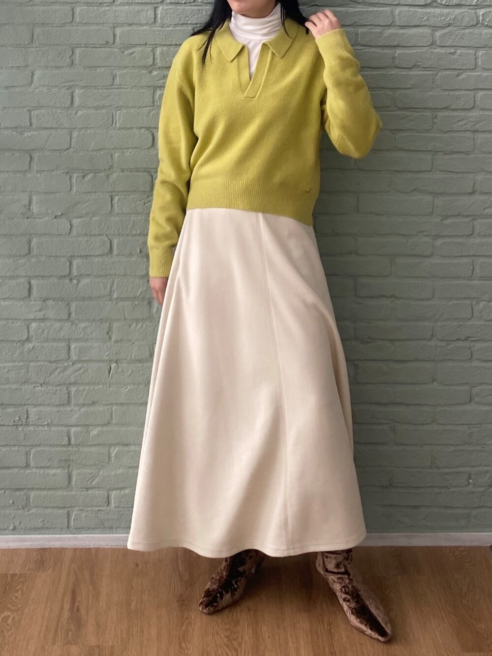 ホワイト系のTシャツ/カットソー、ホワイト系のスカート、イエロー系のニット/セーターを着用したレディースの秋コーディネートの2枚目の写真