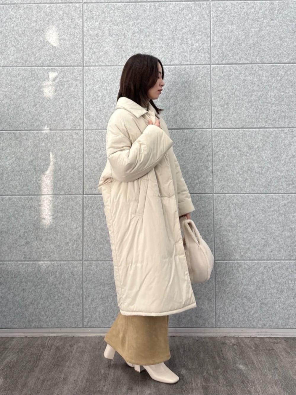 ベージュ系のその他アウター、ブラウン系のスカート、ベージュ系のニット/セーターを着用したレディースの冬コーディネートの2枚目の写真