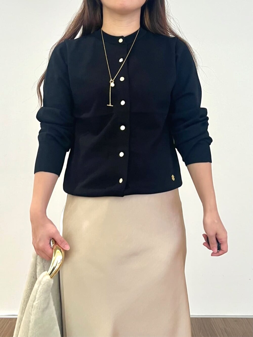 ベージュ系のスカート、ブラック系のカーディガン/ボレロを着用したレディースの秋コーディネートの4枚目の写真