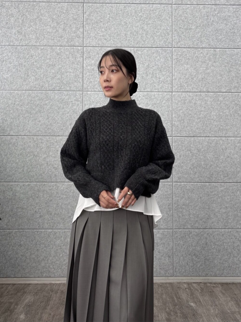 グレー系のスカート、グレー系のニット/セーターを着用したレディースの秋コーディネートの6枚目の写真