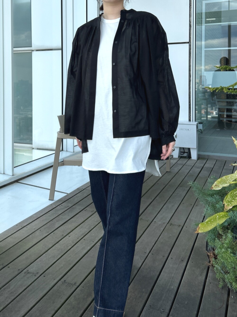 ブルー系のデニムパンツ、ホワイト系のTシャツ/カットソー、ブラック系のシャツ/ブラウスを着用したレディースの春コーディネートの4枚目の写真