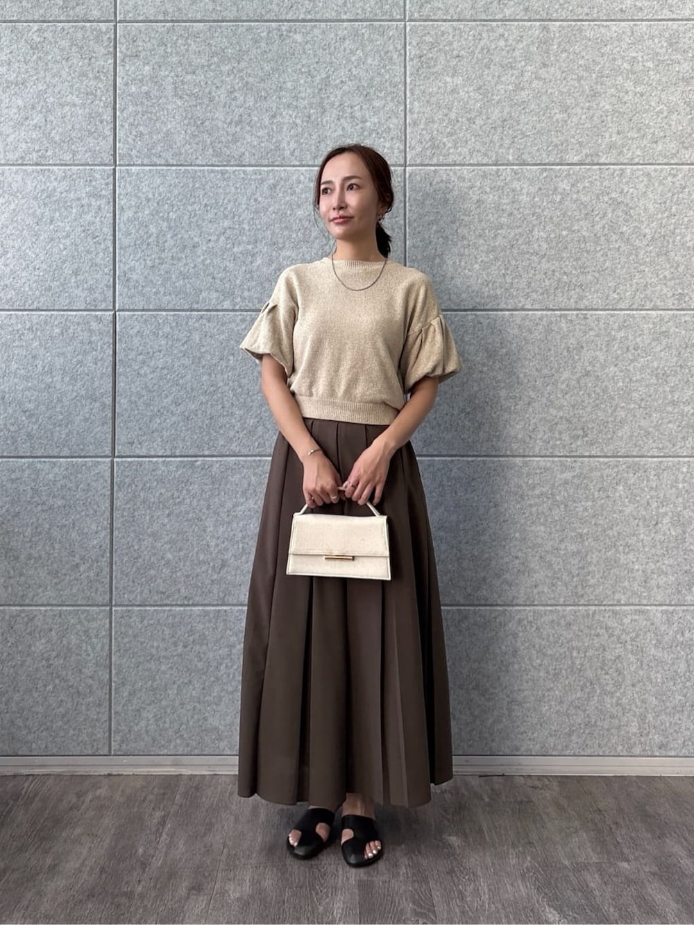ベージュ系のTシャツ/カットソー、ブラウン系のスカートを着用したレディースの夏コーディネートの2枚目の写真
