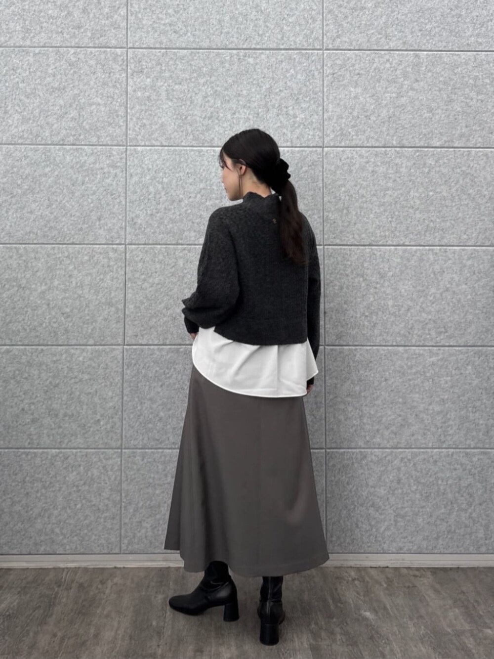 グレー系のスカート、グレー系のニット/セーターを着用したレディースの秋コーディネートの4枚目の写真