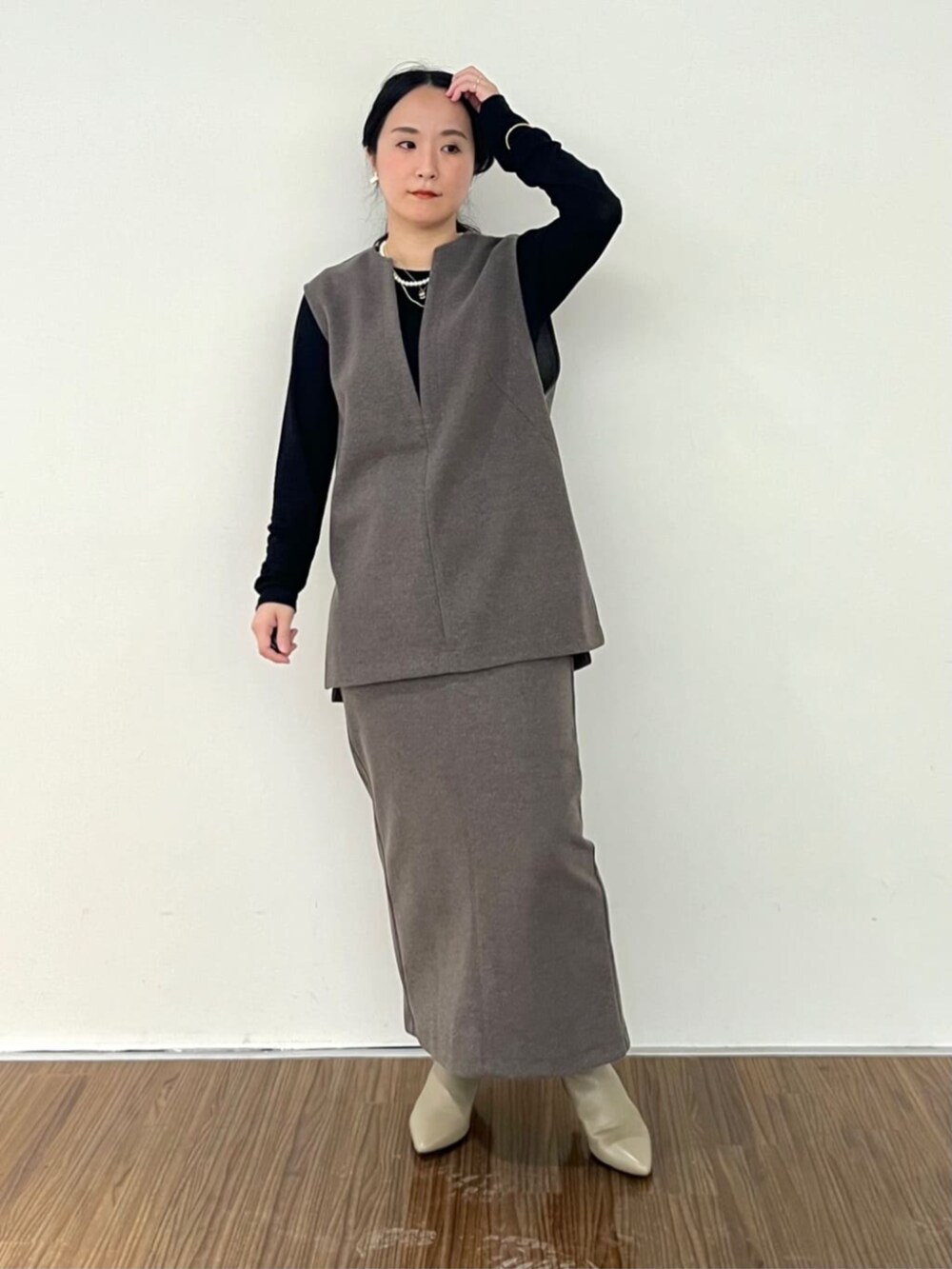 ブラウン系のベスト、ブラウン系のスカート、ブラック系のTシャツ/カットソーを着用したレディースの秋コーディネートの2枚目の写真