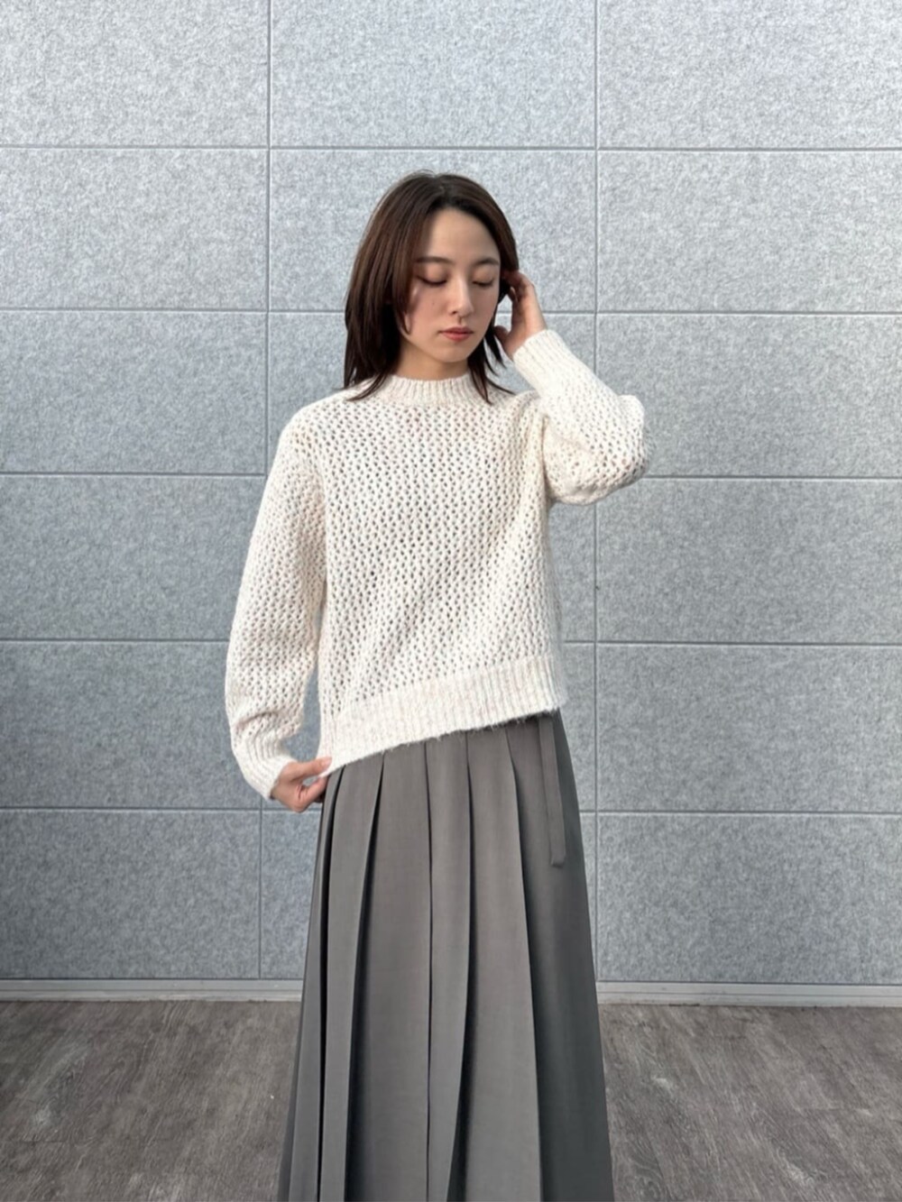 グレー系のスカート、ホワイト系のニット/セーターを着用したレディースの秋コーディネートの4枚目の写真