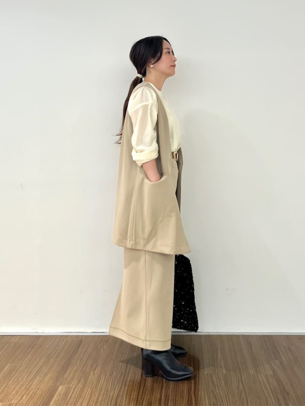 ブラウン系のスカート、ホワイト系のシャツ/ブラウス、ブラウン系のベストを着用したレディースの秋コーディネートの3枚目の写真