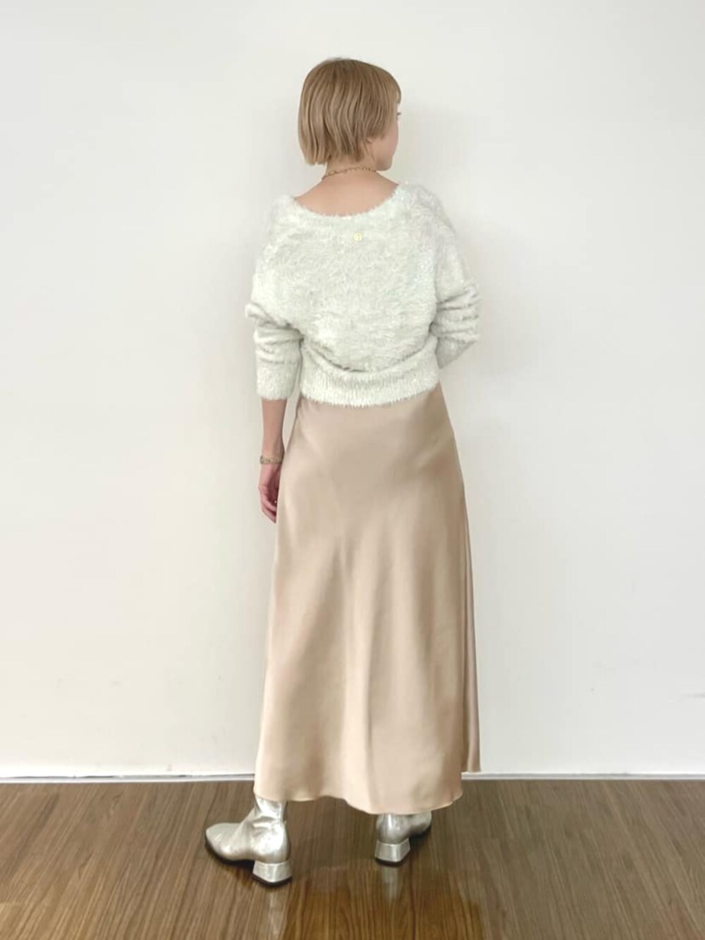 ベージュ系のスカート、ホワイト系のカーディガン/ボレロを着用したレディースの冬コーディネートの4枚目の写真