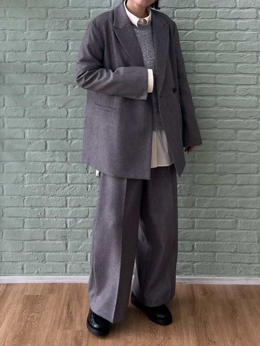 グレー系のテーラードジャケット、グレー系のその他パンツ、グレー系のニット/セーターを着用したレディースの秋コーディネートの2枚目の写真