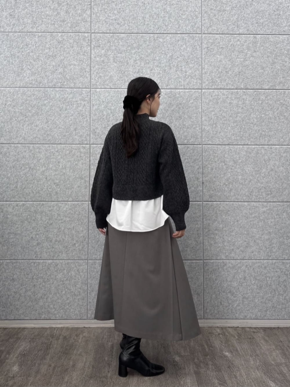 グレー系のスカート、グレー系のニット/セーターを着用したレディースの秋コーディネートの2枚目の写真