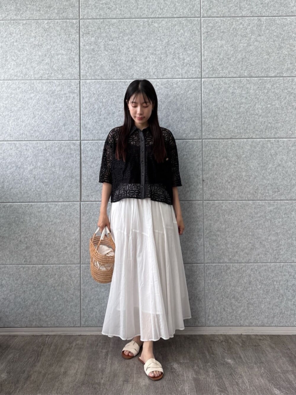 ホワイト系のスカート、ブラック系のシャツ/ブラウスを着用したレディースの夏コーディネートの4枚目の写真