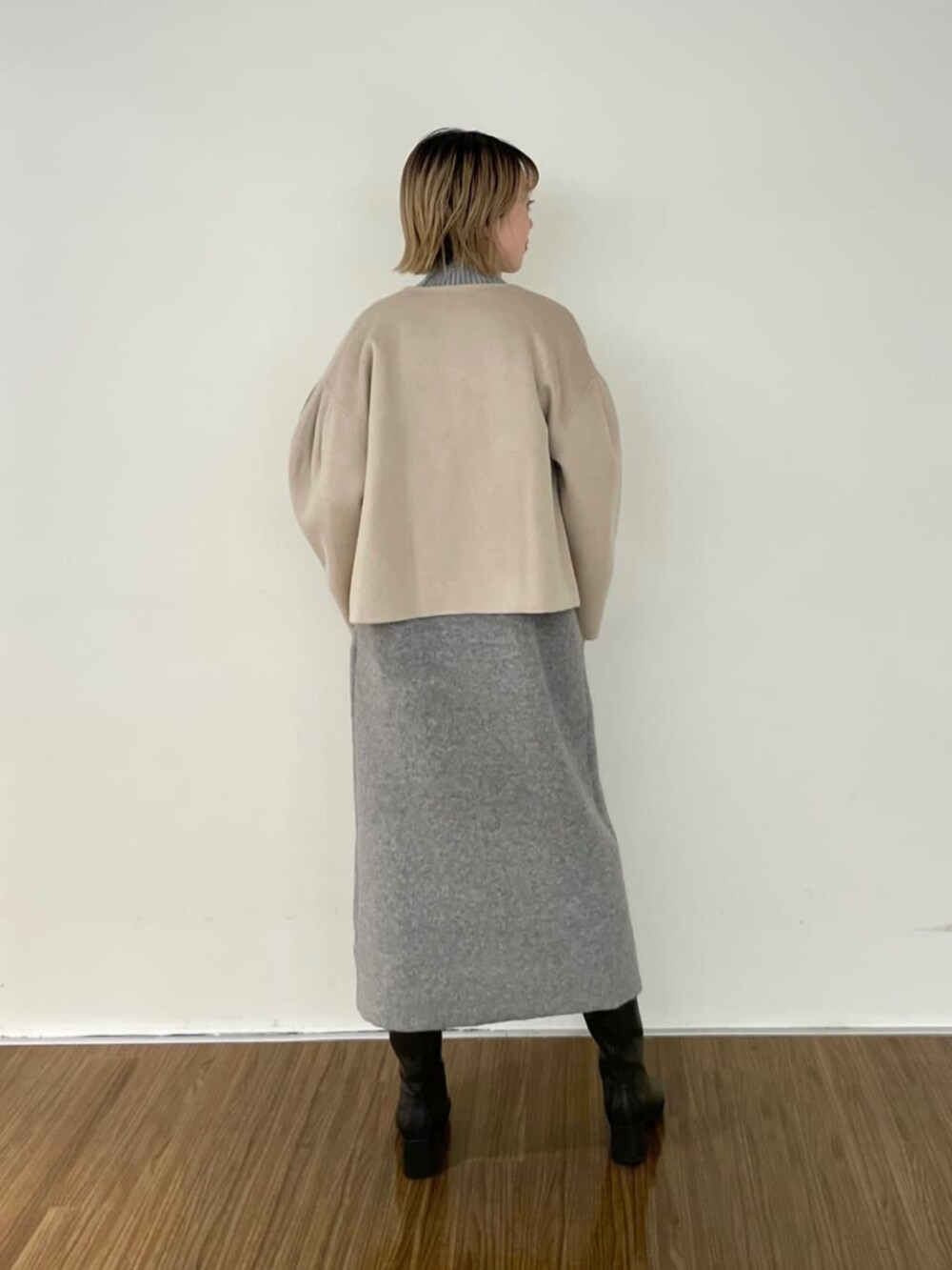 グレー系のワンピース、ベージュ系のノーカラーコートを着用したレディースの秋コーディネートの4枚目の写真